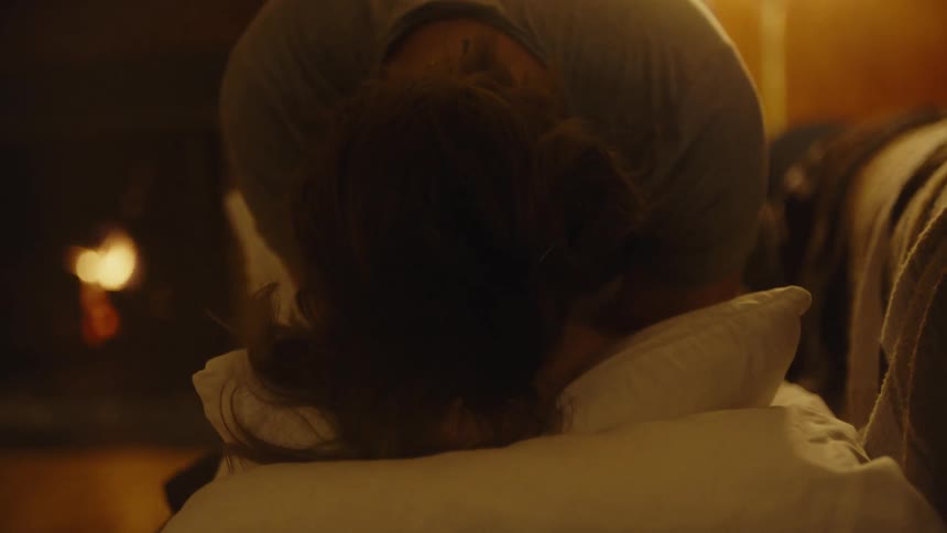 Womans head against a pillow with a body expression of contraction and pain