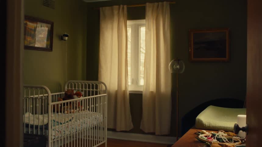 Room with a crib containing stuffed animals a window with sheer curtains and various items scattered around