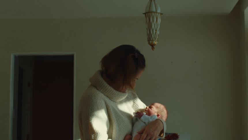 Mother with her baby on her lap in a room