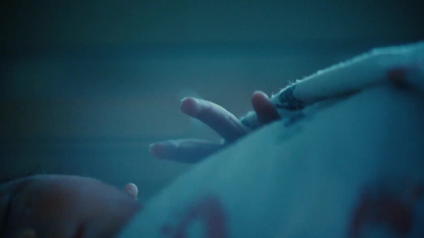 Newborn baby lying down moving his fingers