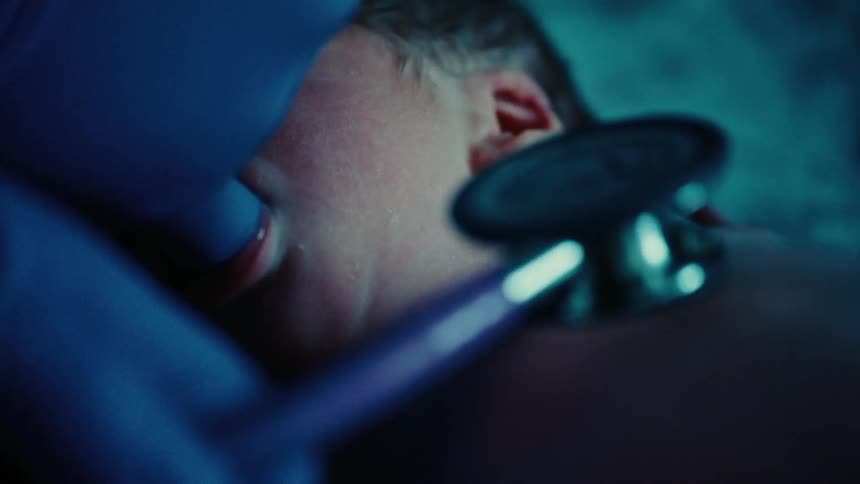 Closeup of a newborn baby and the gloved hands of a healthcare professional checking his lungs