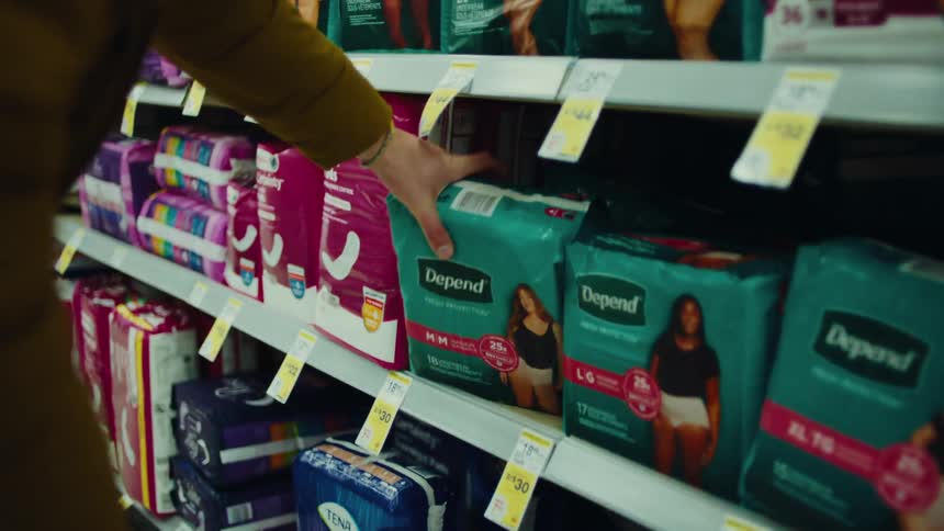 Hand picking up a pack of adult diapers