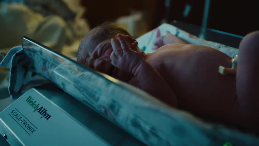 Newborn lying on a medical scale