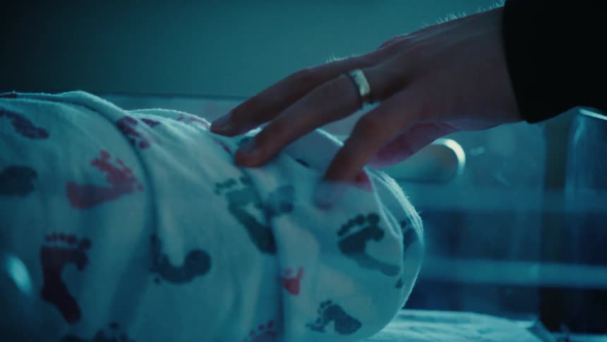 Persons hand covered in a newborn babys wrap