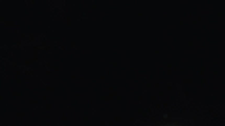 Moving upward view of a night street with streetlights