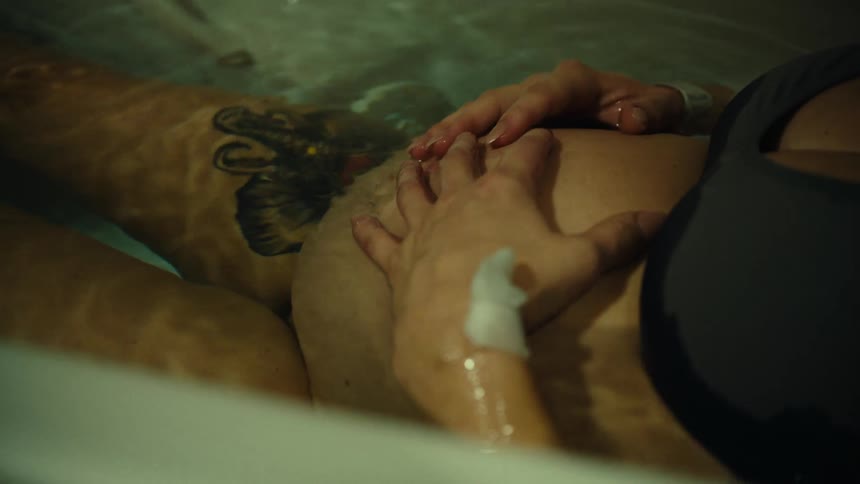 A pregnant woman rubs her belly