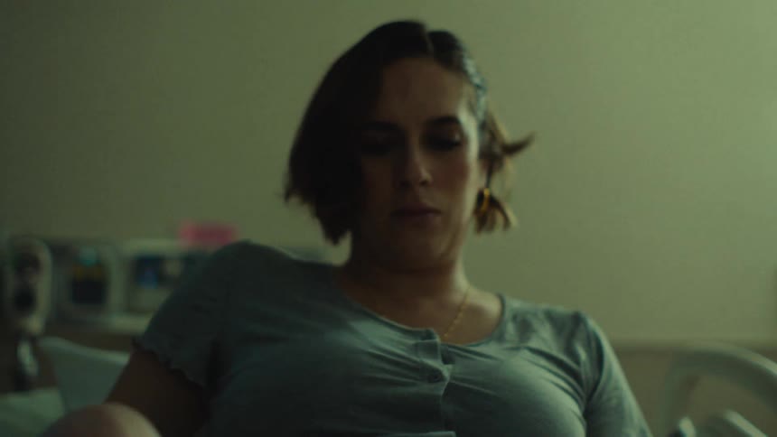 A nervous patient lays down in a hospital bed and puts her knees up