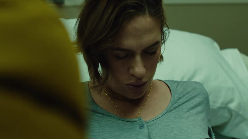 Pregnant woman lying down taking deep breaths in labor at hospital