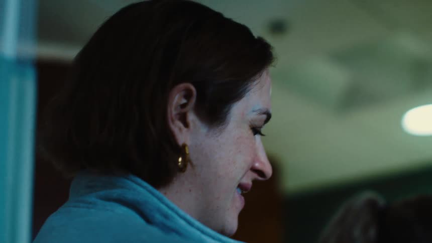 A woman smiles while another woman grabs something in front of her