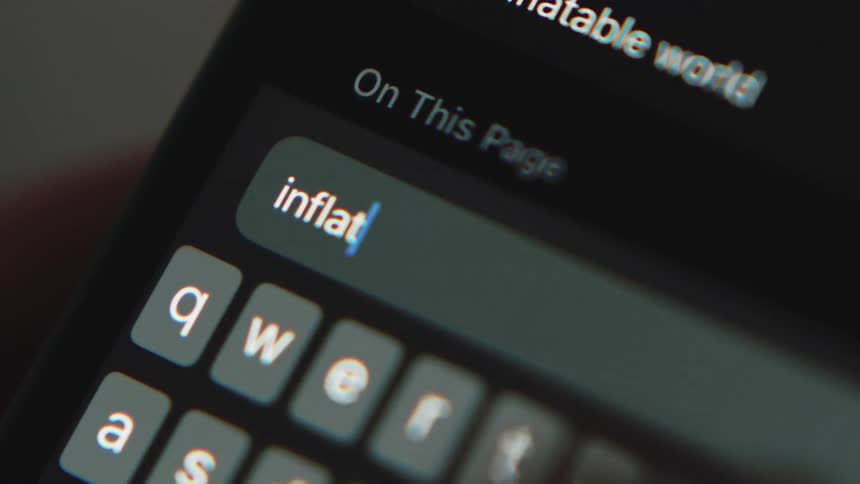 Close up of persons hand texting inflation on smartphone