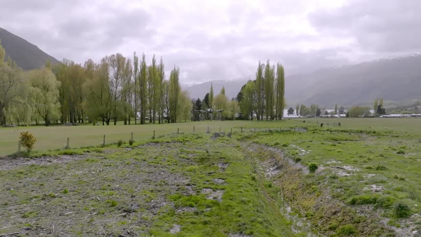 Drone flying above a green field
