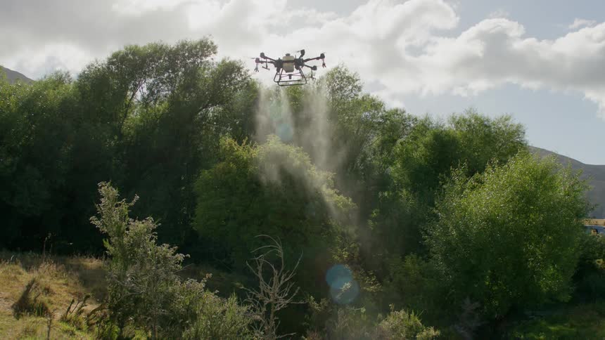 Drone dropping water on trees in a natural environment