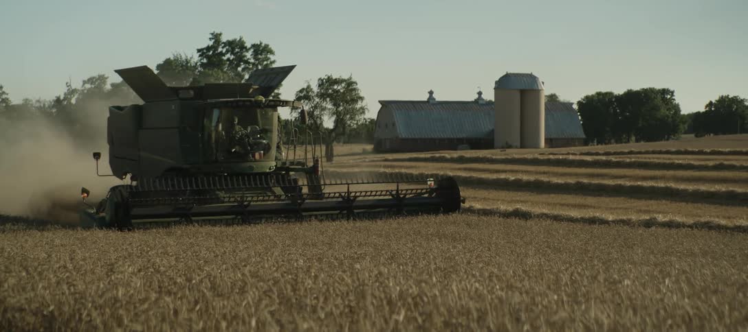 A combine harvester plowing a field