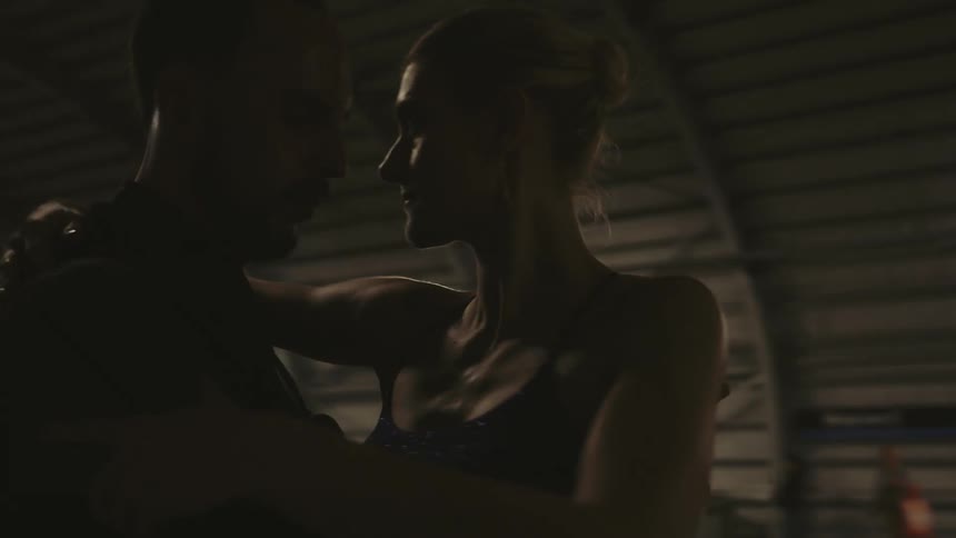 An elegant couple dancing on the platform of a subway station