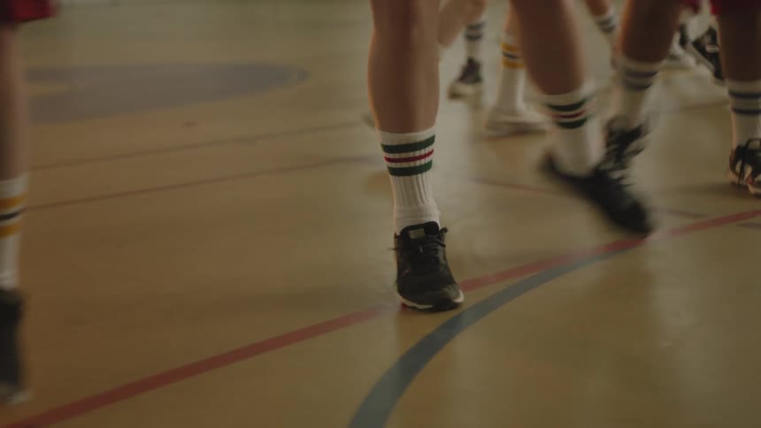 Legs of students on a court running sideways