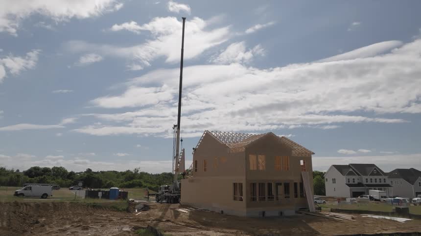 Unfinished house under construction with a crane in the background