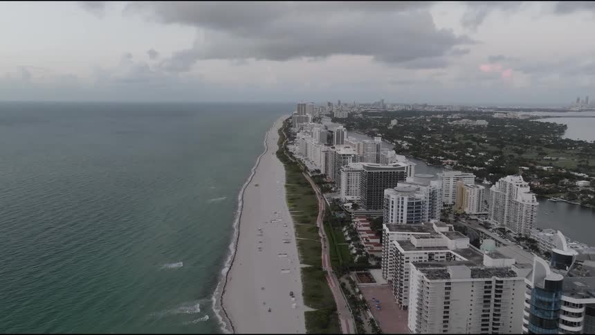 An aerial view of a coastal city with highrise buildings lining the beach