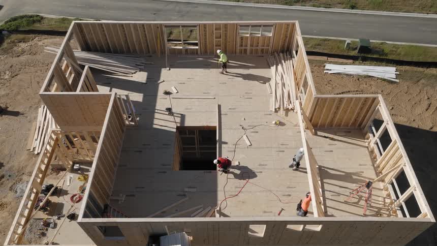 A group of workers assembling a wooden structure at a construction site