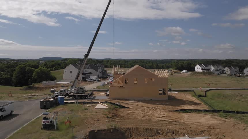 A large crane working on the construction of a house