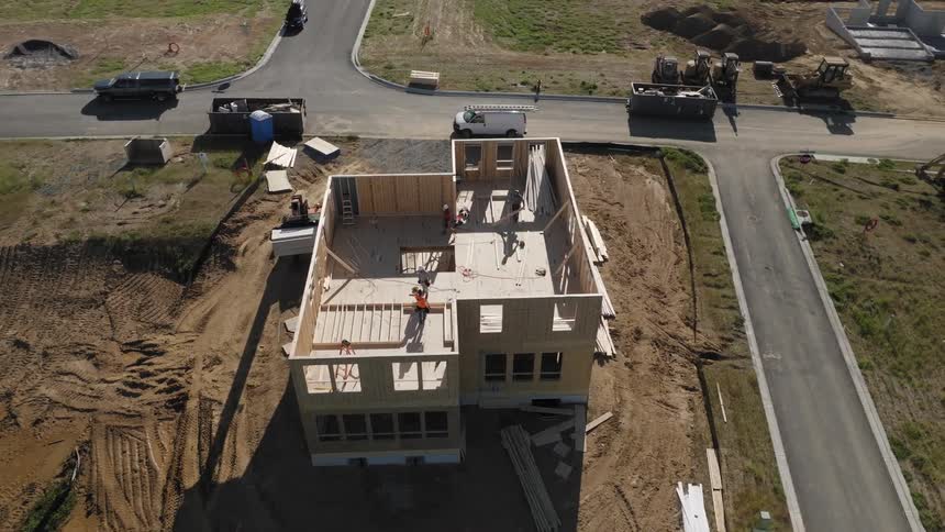 Aerial view of a partially completed wooden framework of a building at a construction site