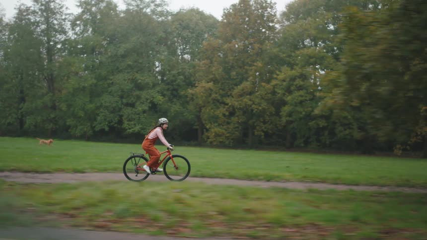 A woman cycling on a park trail