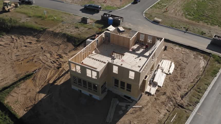 Construction of a twostory house in the initial phase with the wooden structure partially completed