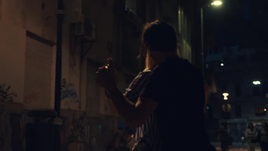 A couple dancing in an alley under the street lights at night
