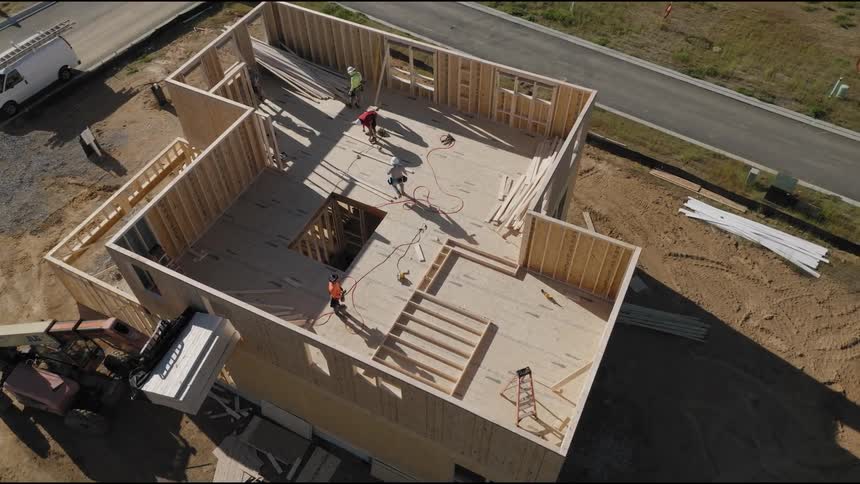 Aerial view of a twostory house under construction with people working