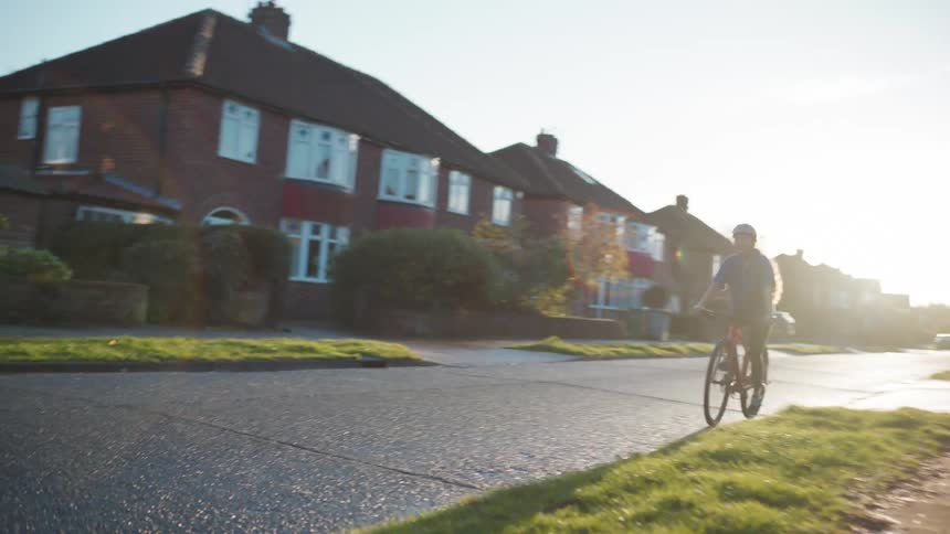 Girl riding a bike on a street in a residential neighborhood