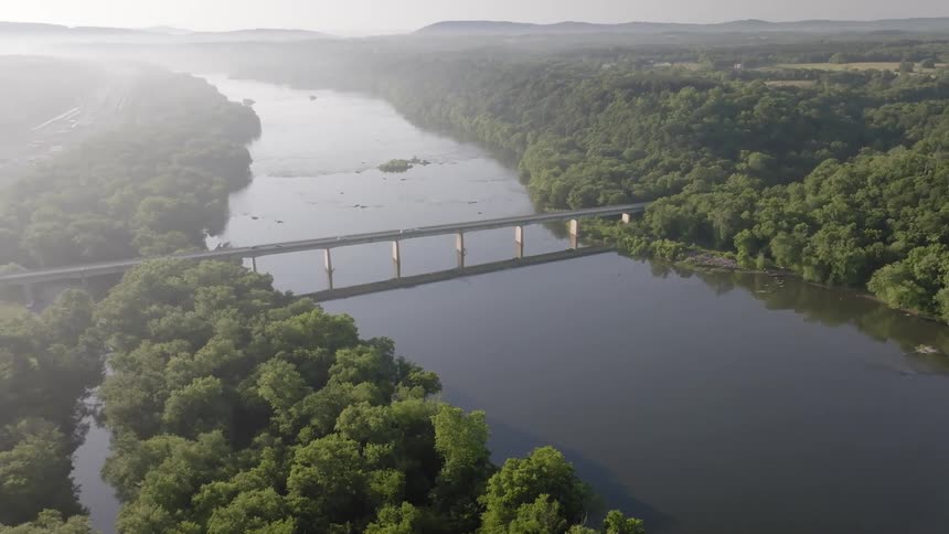 Aerial view of a bridge above a sea channel and surrounded by forests