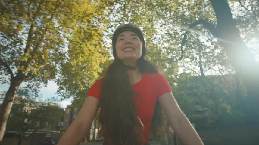 Woman with a smile on her face riding a bicycle with trees around