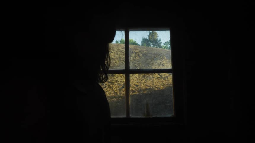 A person sits up in front of a window