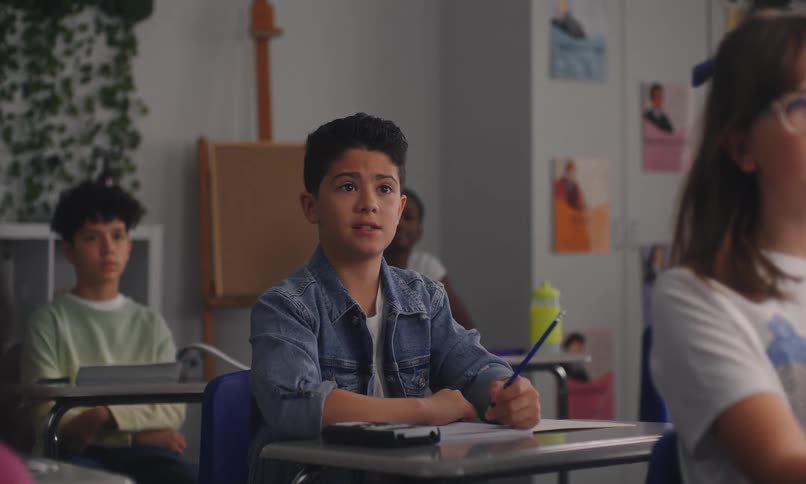 Student raises his hand and speaks to his teacher during class