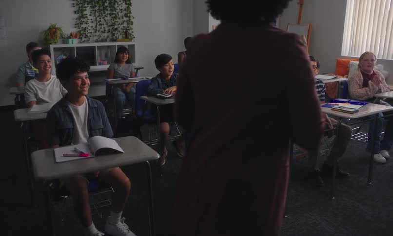 A group of students answer excitedly to the teacher whos speaking to them