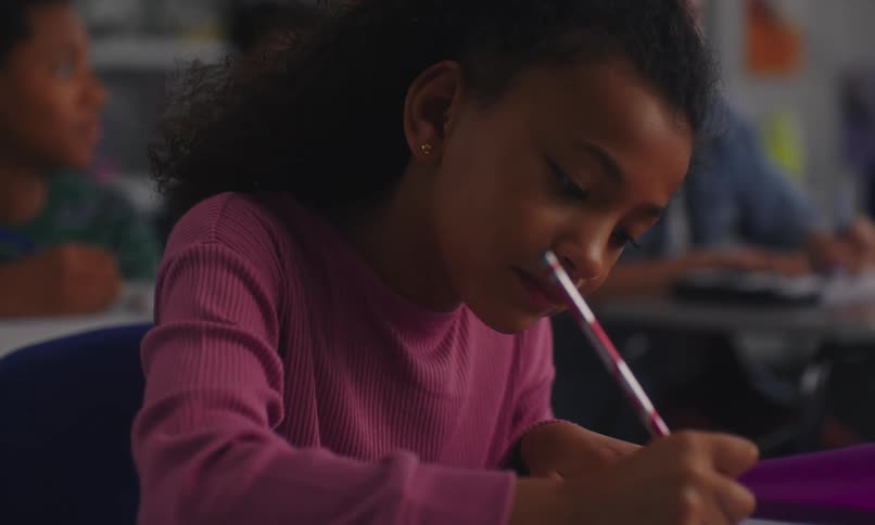 Students pay attention in class and a female student takes notes