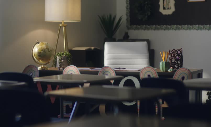 A wellorganized room with a desk chair lamp and decorative items suggesting a modern classroom