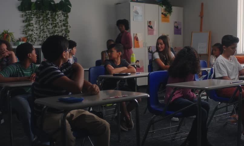 Students sitting on a classroom listening to a teacher
