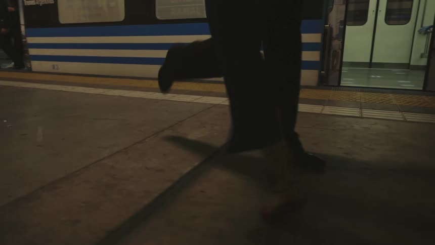 Man and woman performing a dance together next to a train at a subway station