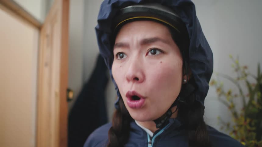 Woman wearing a bicycle helmet psychs herself up as she prepares to go out