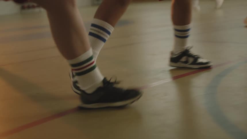 A closeup of a croup of people lower legs wearing black and white sneakers while exercising