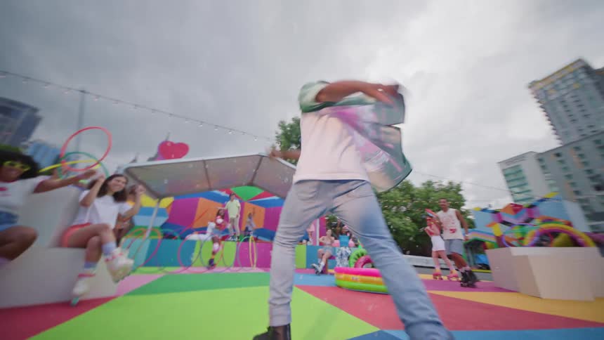 Youths enjoy themselves at a colorfully decorated urban skate park while bubbles fill the air