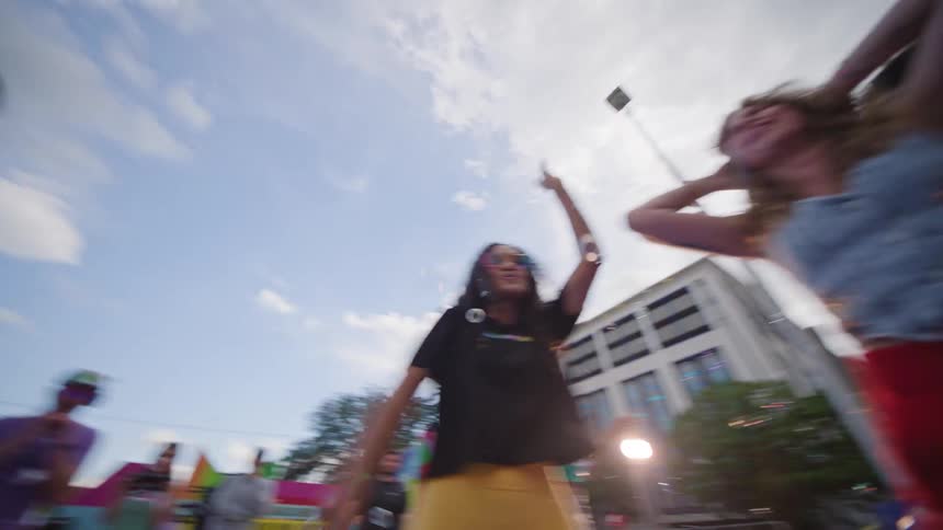 Group of people wearing colorful clothes dancing and cheering