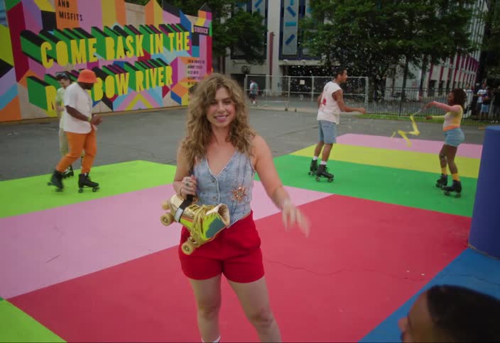 A colorful outdoor scene with several individuals on a vibrant multicolored ground resembling a dance floor