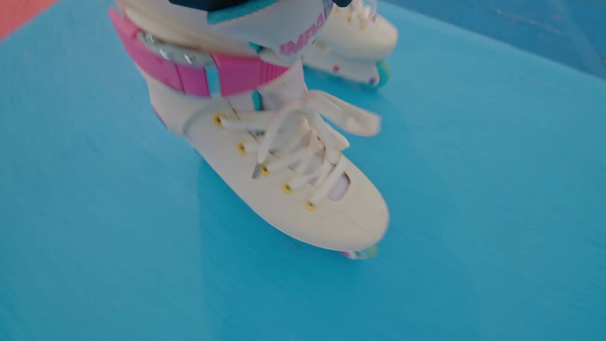 Someones feet using a roller skate going over a colored floor