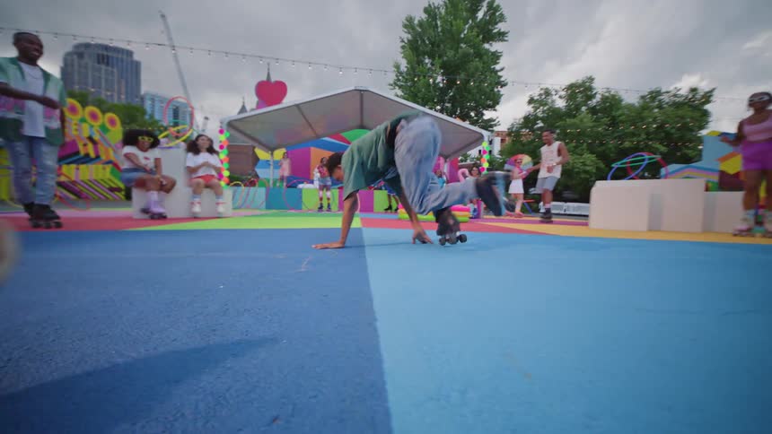 Man on roller skates dancing on playground surrounded by other people