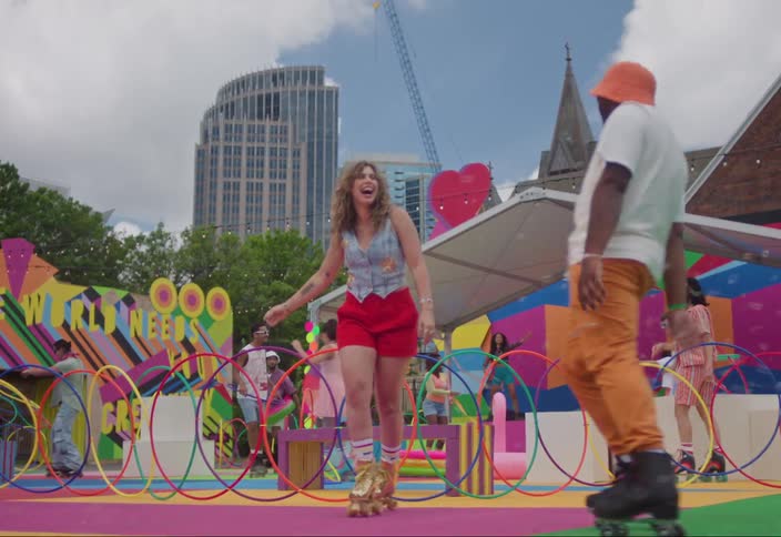 A couple in colorful clothes and roller skates dancing at an urban playground in the city