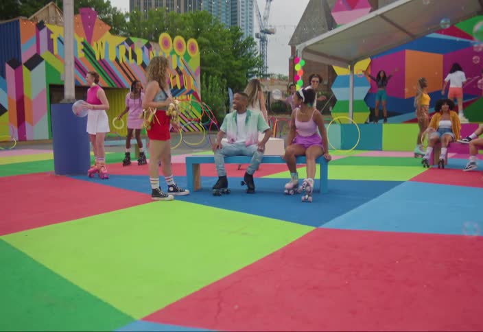 Group of people with roller skates on a colorful playground and soap bubbles flying around