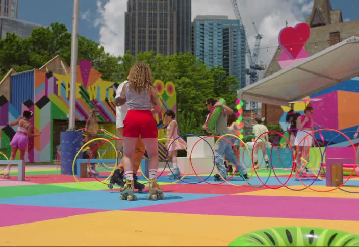 Group of people on colorful playground dancing and playing roller skates