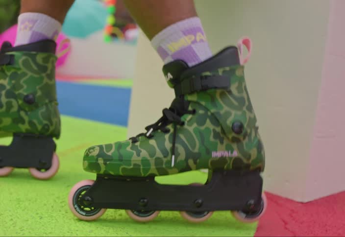The camera zooms and orbits camo pattern roller skates