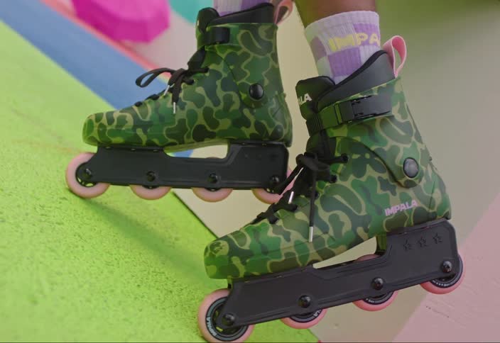 Legs of a person with green camouflage skates